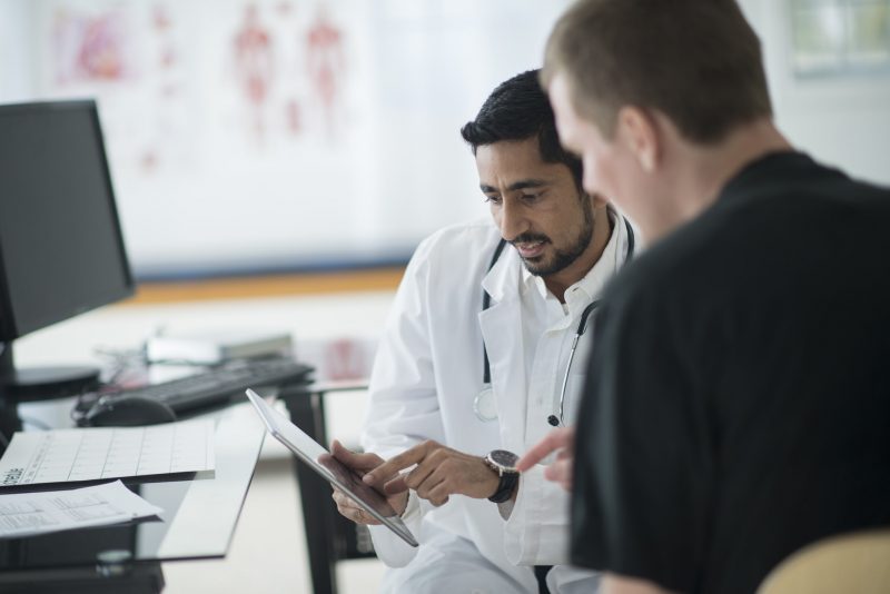 A doctor reviews clinical information on a mobile device