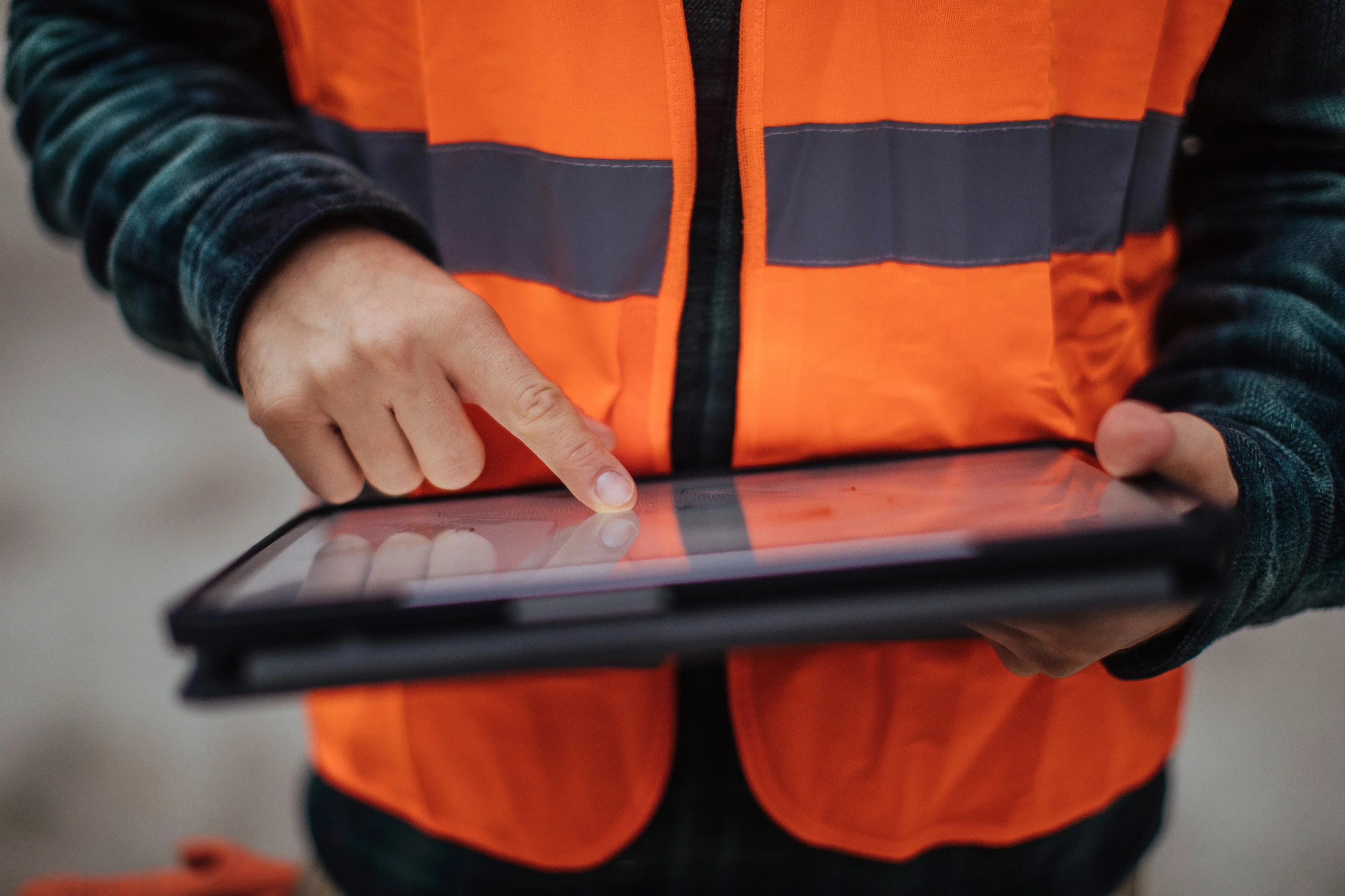 Field engineer in high vis on a tablet