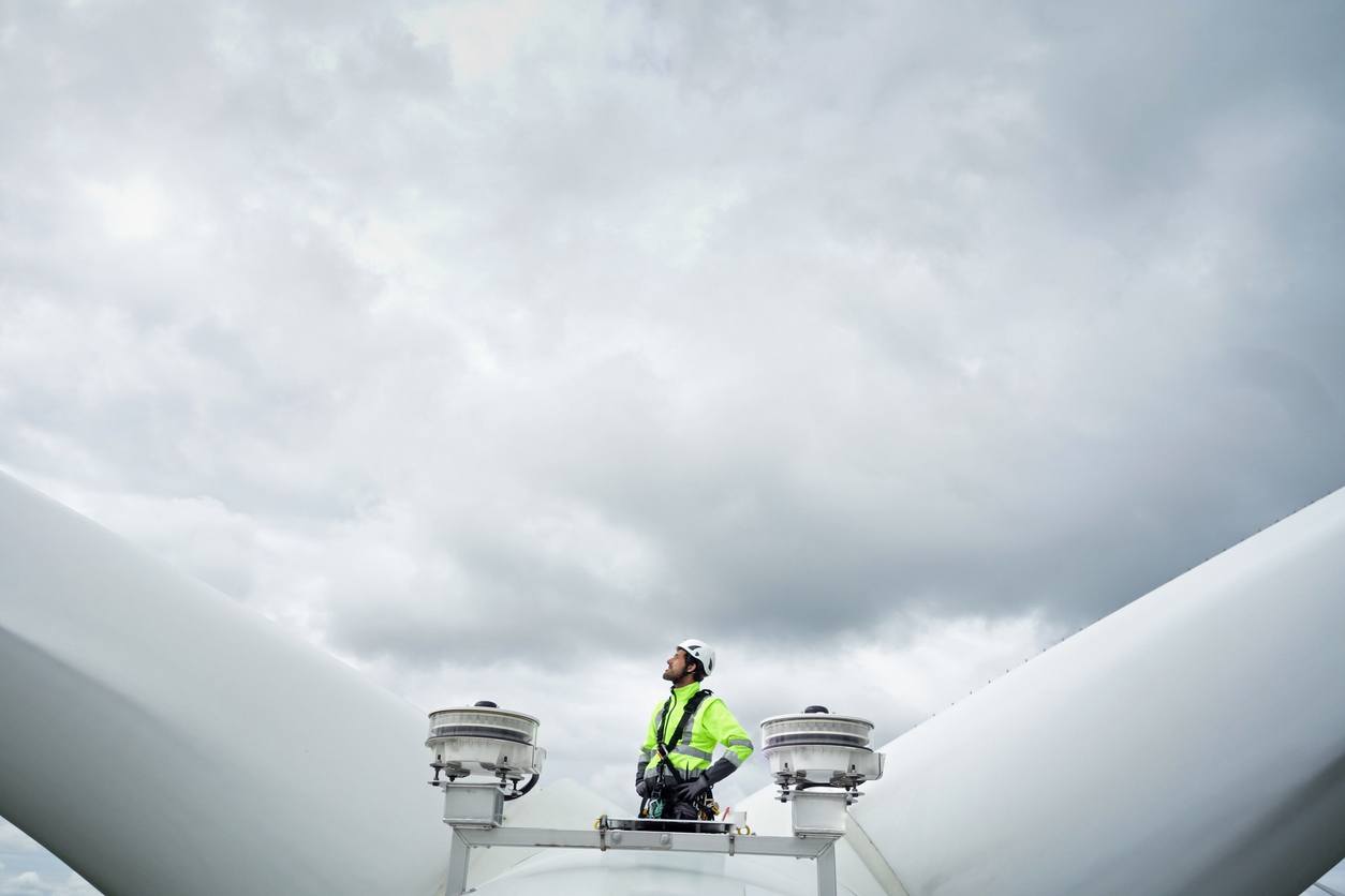 Service engineer working outside of access hatch on large windmill.