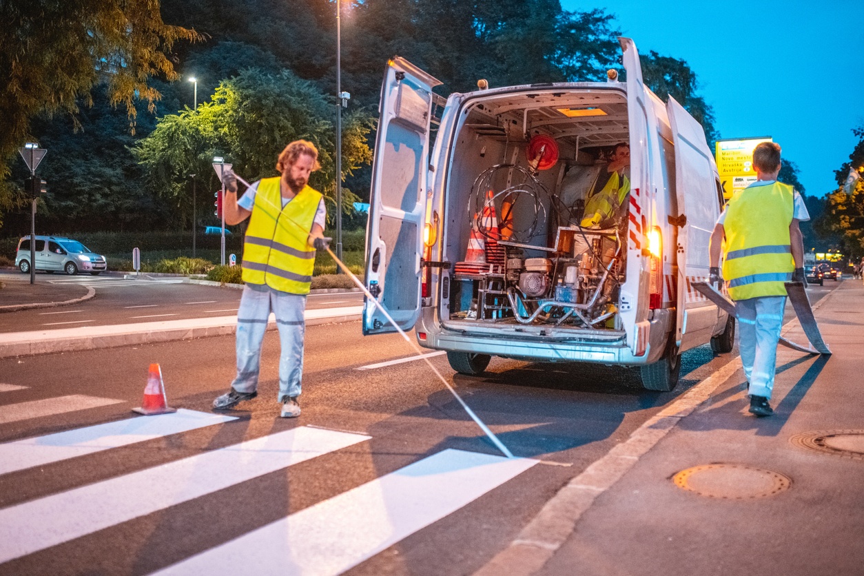 Road maintenance technicians completing utilities street works improvement in yellow high-vis outfits.