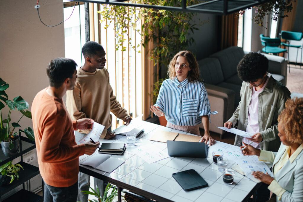 Group of office professionals planning days activities in group meeting room.