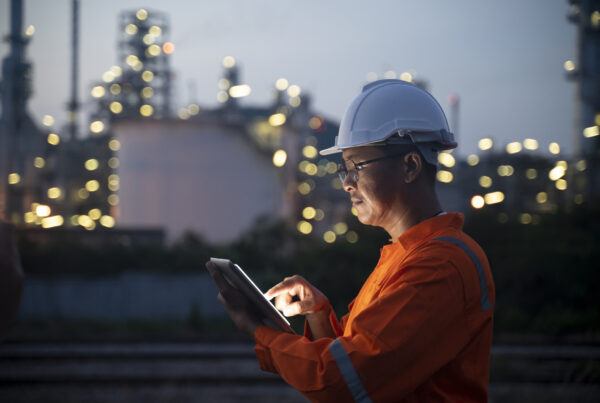 Field engineer in helmet holding a tablet