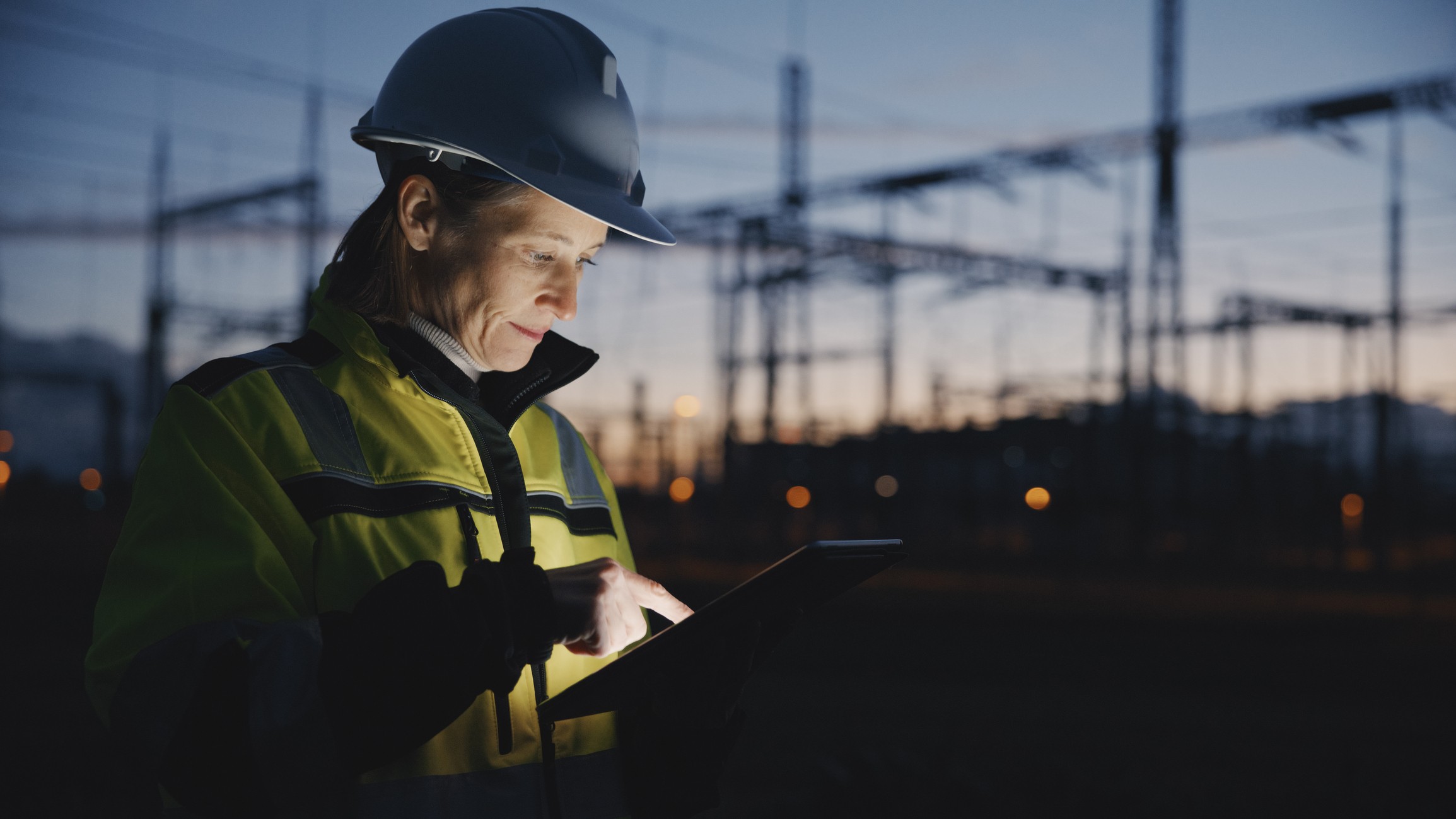 Field service engineer wearing helmet and high vis using a tablet